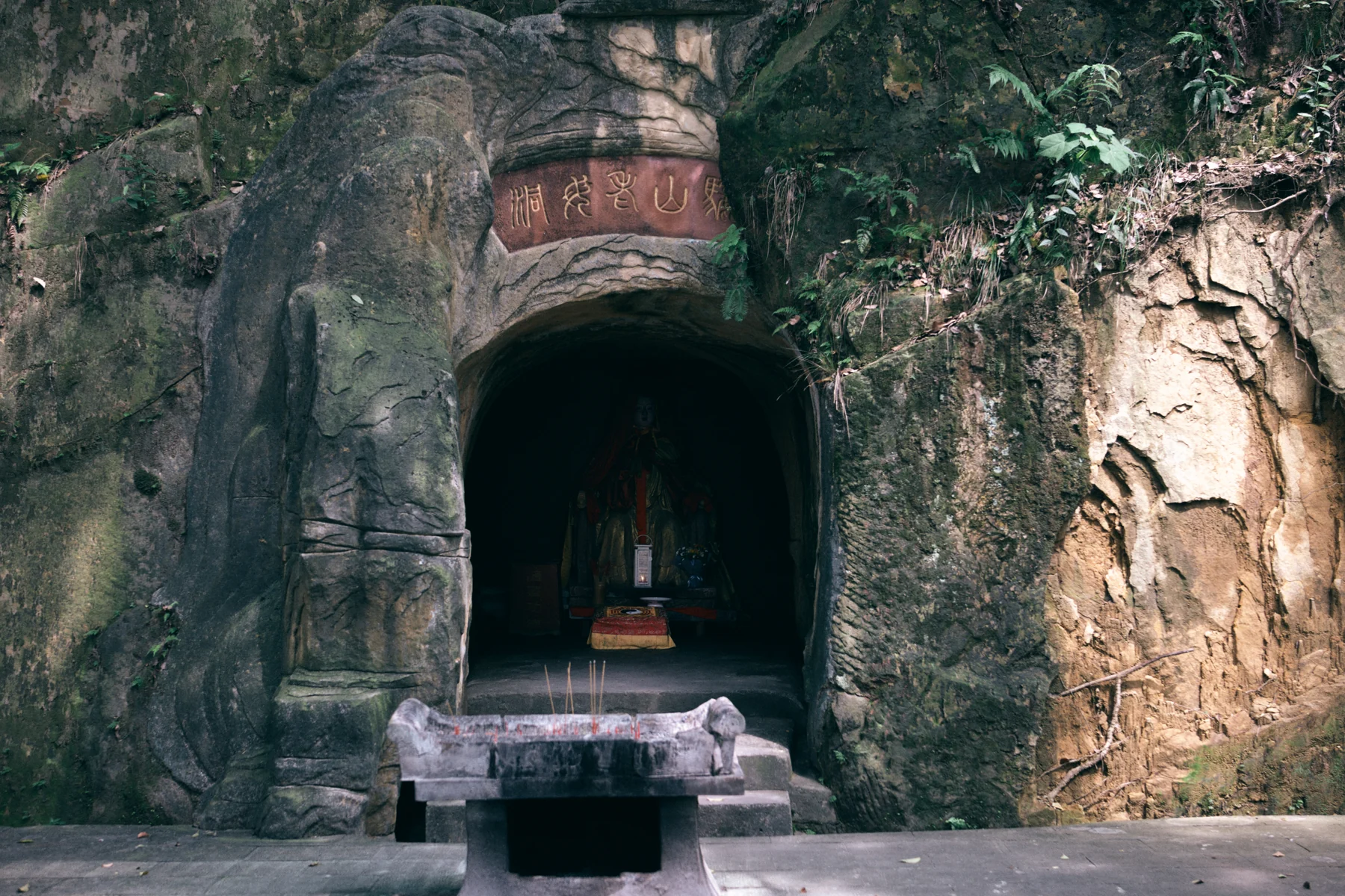 Rock-cut cave entrance at Laojundong in daylight, photographed in 2023